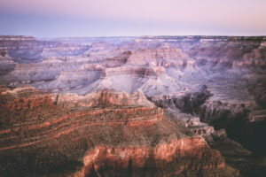 he Grand Canyon at sunrise with a purple sky. Southwest Region Travel Guide
