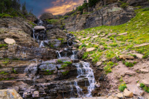 Scenic mountain landscape with a cascading waterfall along Going-to-the-Sun Road in Glacier National Park