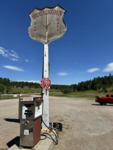 Exterior of Buckhorn Bar and Grill in Buckhorn, Wyoming, featuring a vintage gas pump and weathered sign under open skies