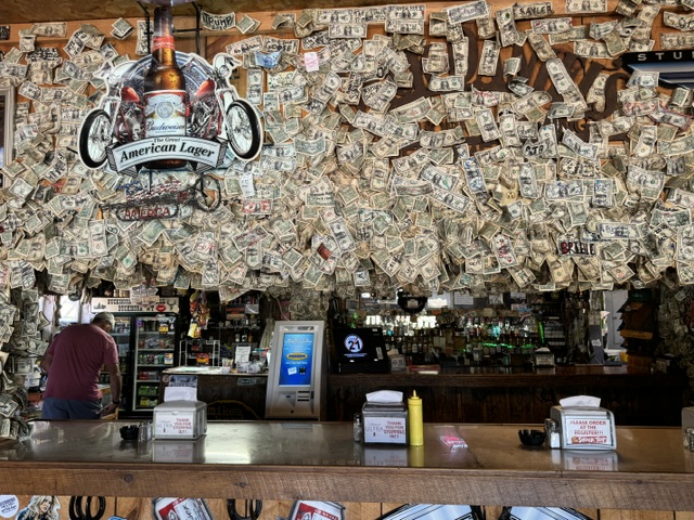 Interior of Buckhorn Bar and Grill in Wyoming with walls covered in signed dollar bills left by visitors