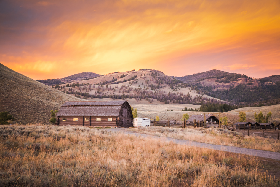 Historic wooden ranger station building set against the vast landscape of Lamar Valley in Yellowstone National Park.