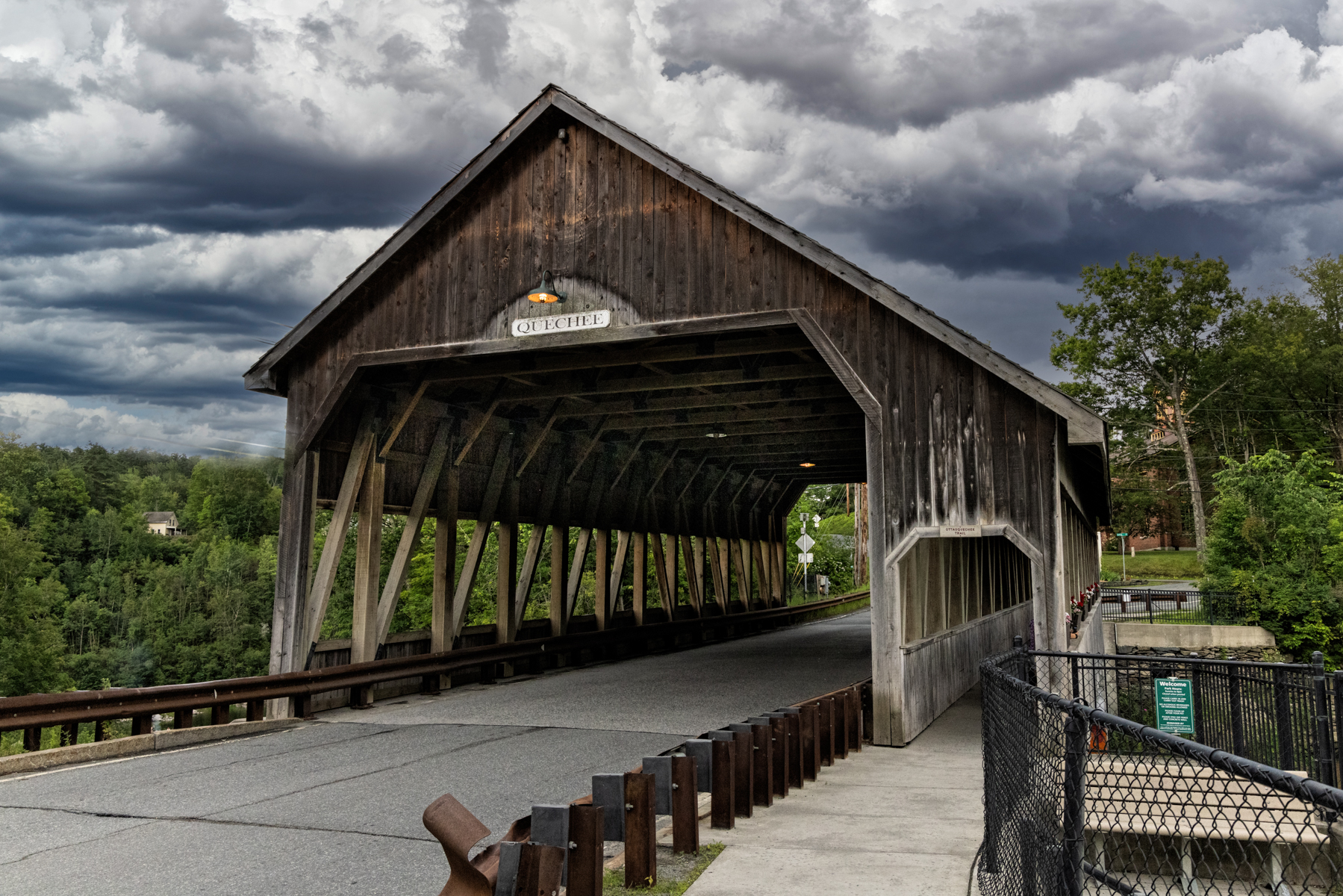Quechee Covered Bridge in Vermont beneath stormy skies, showcasing its historic architecture.