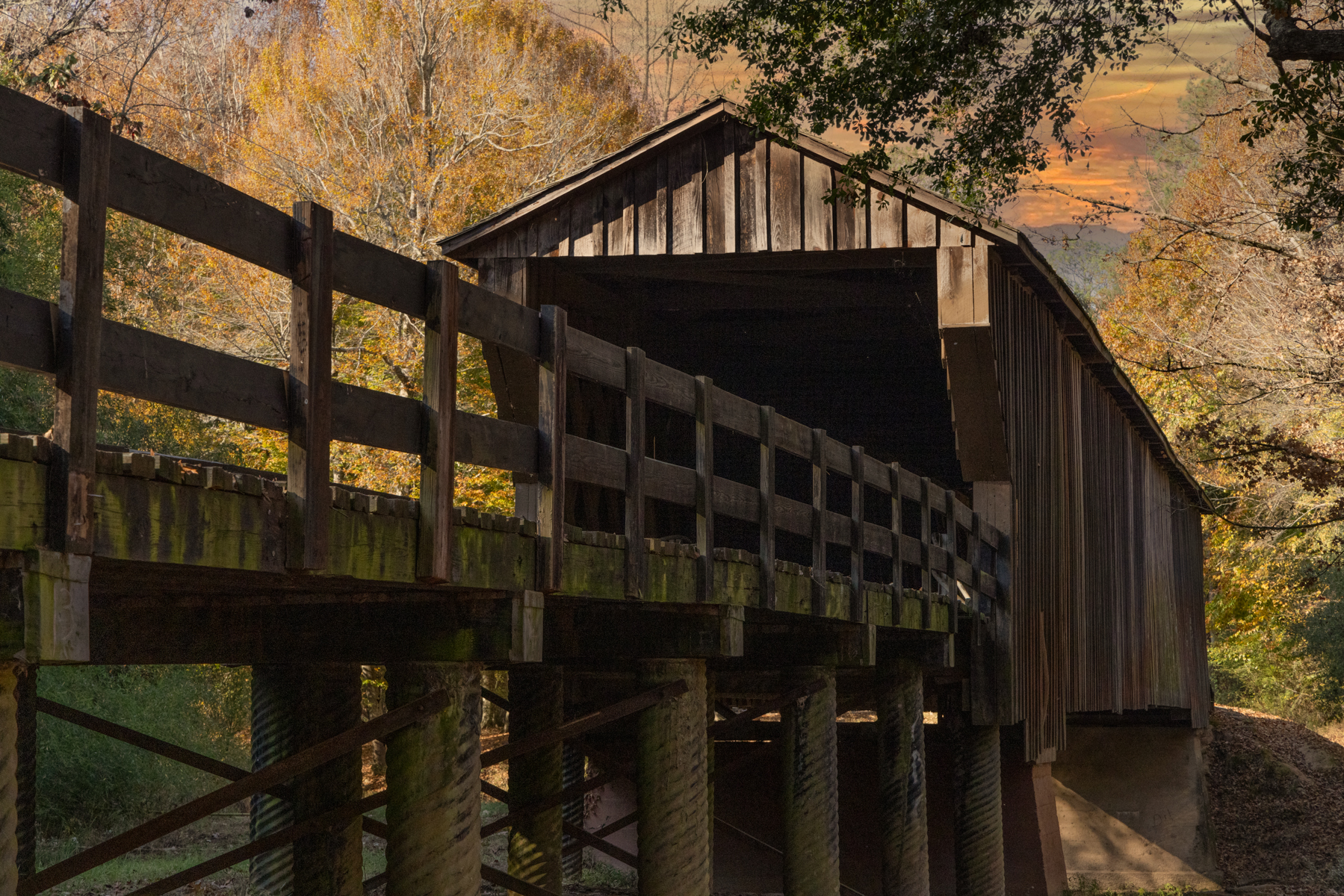Close-up of the Red Oak Creek Covered Bridge in Georgia, illuminated by the golden light of sunset.