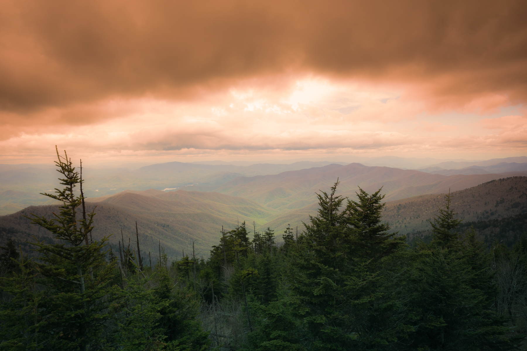 Storm approaching over the Smoky Mountains with dark clouds above misty green peaks in a dramatic landscape view Back roads travel and photography blog