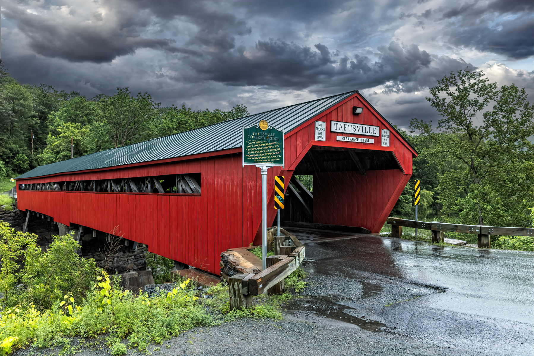 Side view of Taftsville Covered Bridge in Woodstock, Vermont, spanning the Ottauquechee River.