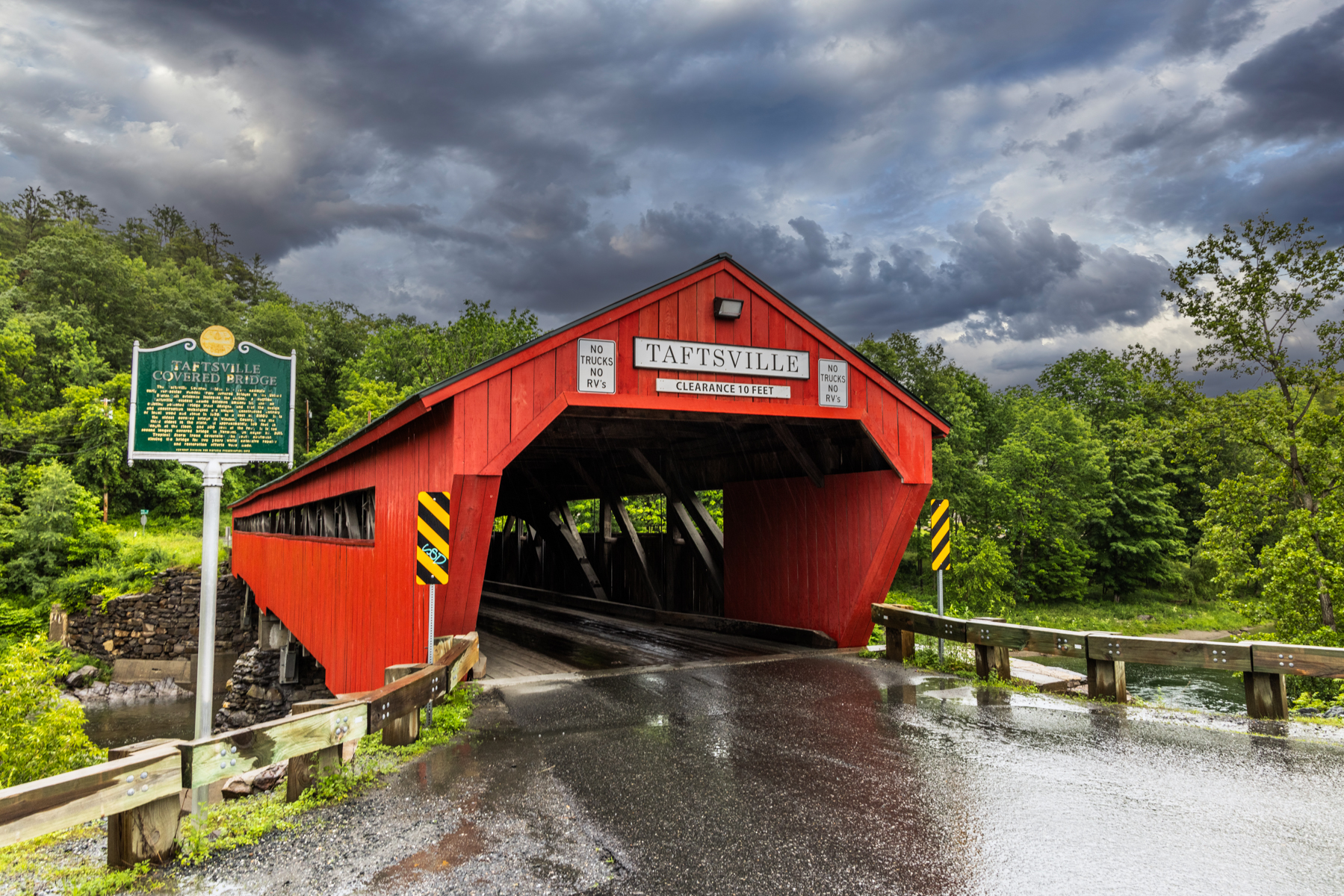 Taftsville Covered Bridge in Vermont with dark, stormy skies overhead.