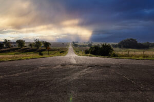 Lonely road at sunset in Kansas. Shows a long desolate road