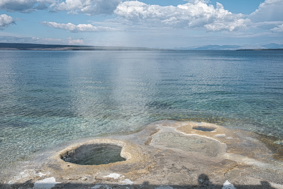 Colorful hot springs bubbling along the shoreline of Yellowstone Lake in Yellowstone National Park.