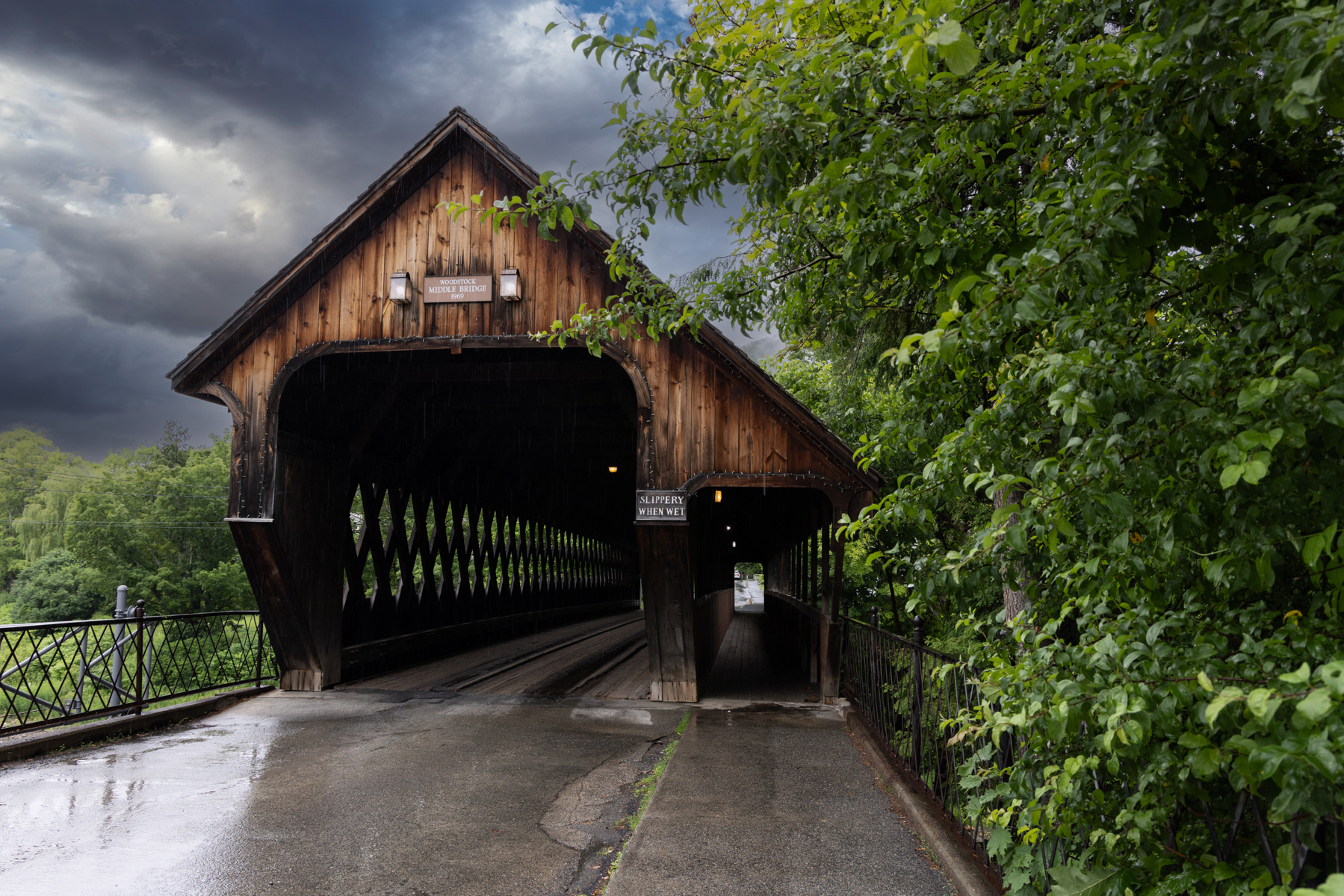 Front view of Woodstock Middle Covered Bridge in Vermont showing red front and natural wood back.