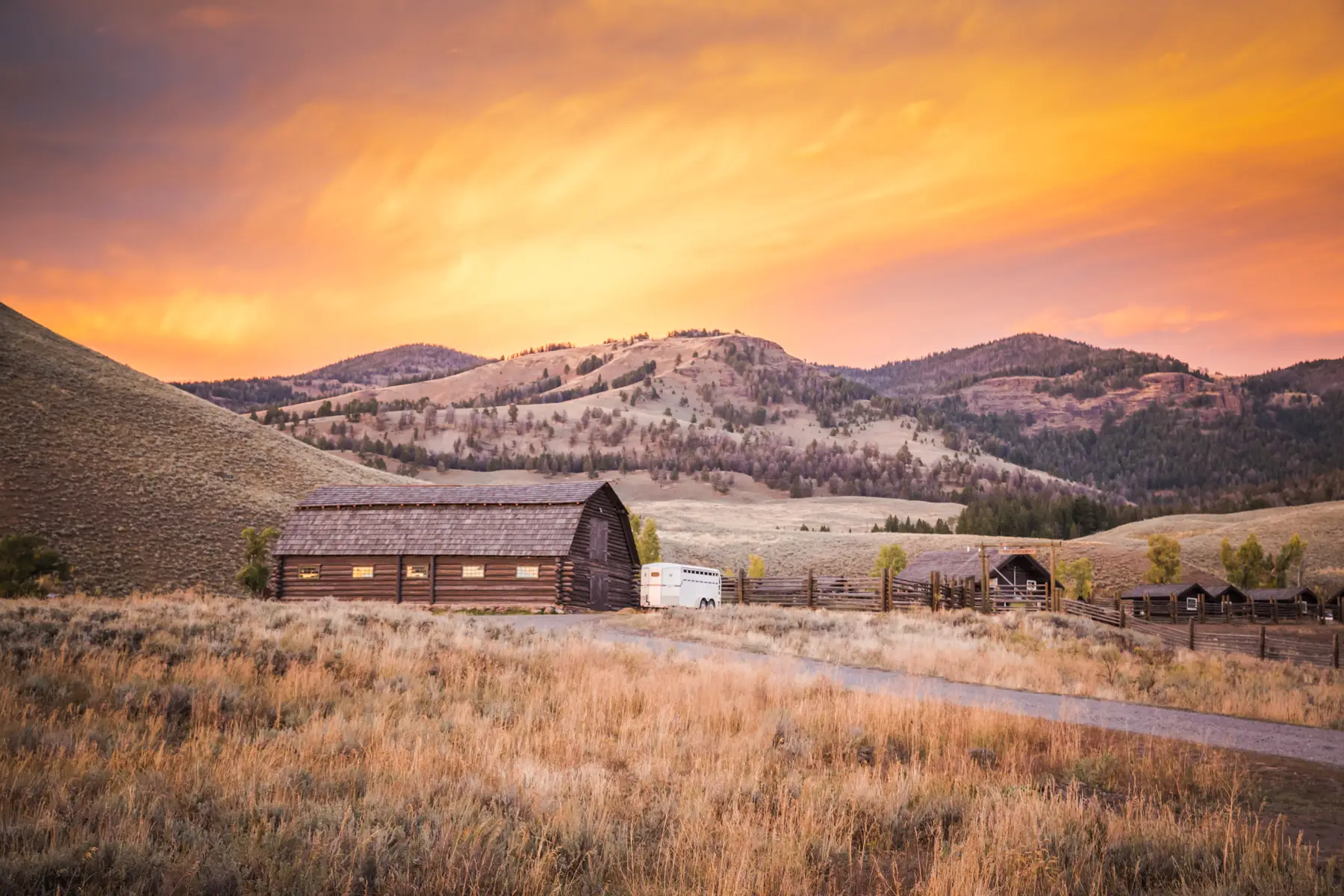 barn with rolling hills at sunset and wheat in the foreground