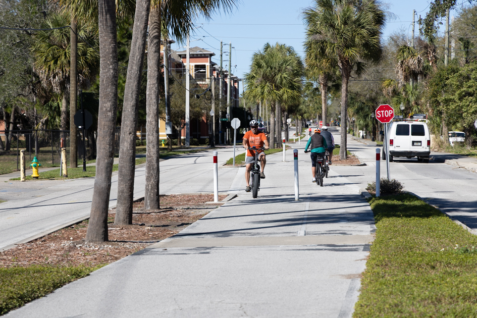 Cyclist riding on a bike path that runs down the middle of the road in Tarpon Springs, Florida

