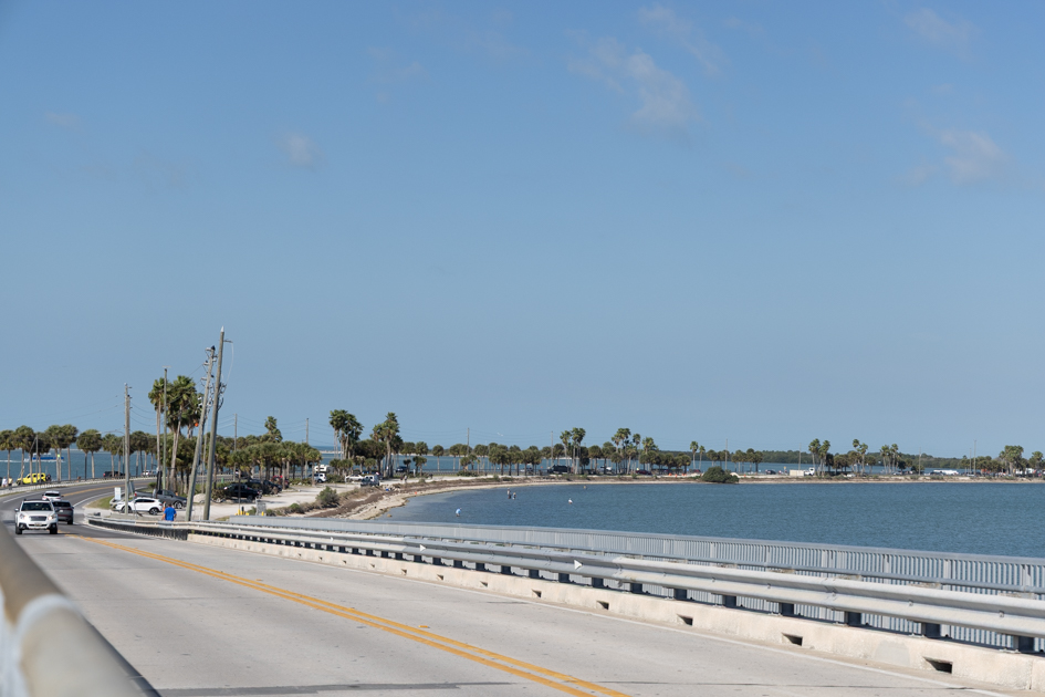 Scenic view of the Dunedin Causeway stretching over the water with blue skies and coastal surroundings
