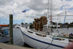 A traditional sponge boat docked in Tarpon Springs with natural sea sponges drying on the deck