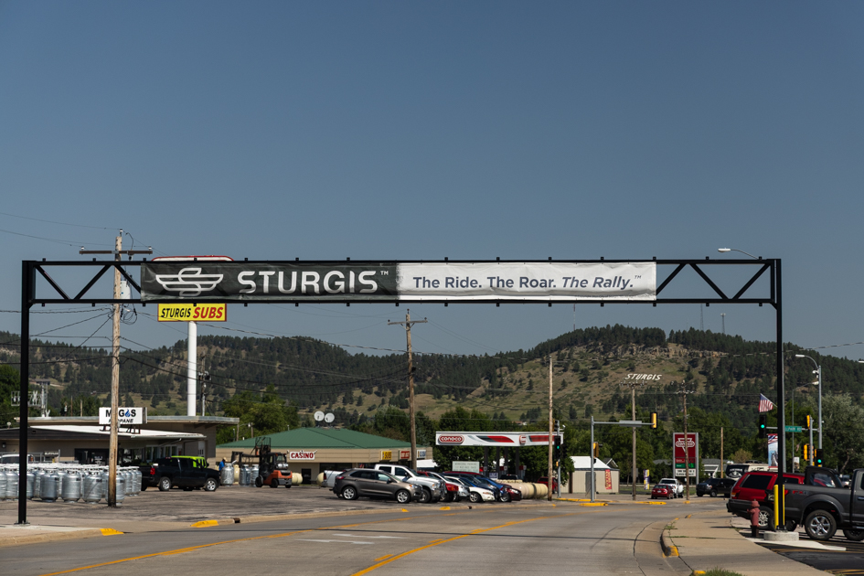 Roadside banner sign welcoming bikers to Sturgis, South Dakota, stretched across a main street.