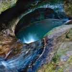 Devil’s Bathtub in Hocking Hills State Park with emerald-green water and smooth sandstone formations