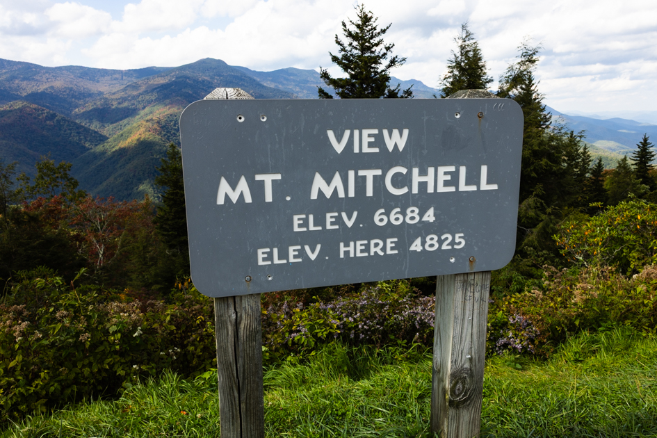 Wooden sign marking the entrance to Mount Mitchell, the highest peak east of the Mississippi River.
