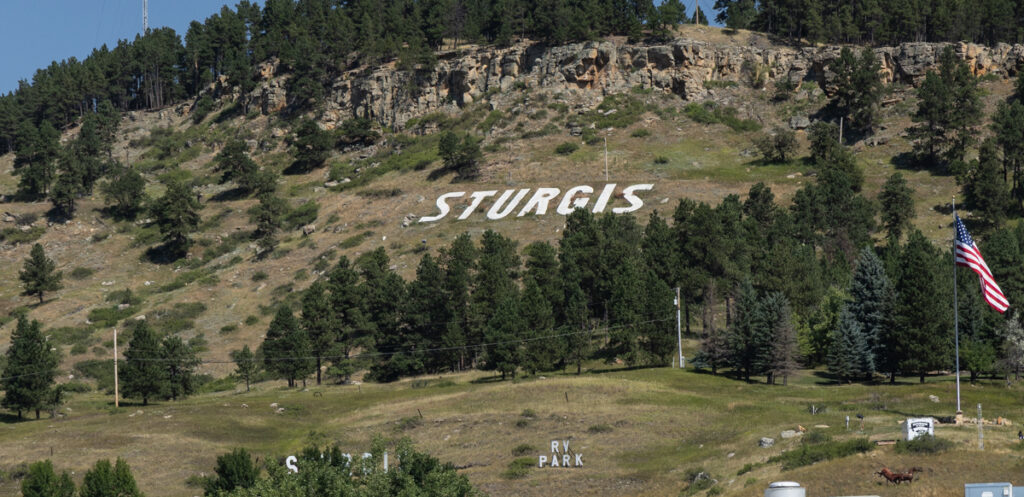 Sturgis spelled out with white rocks on a grassy hillside in South Dakota.