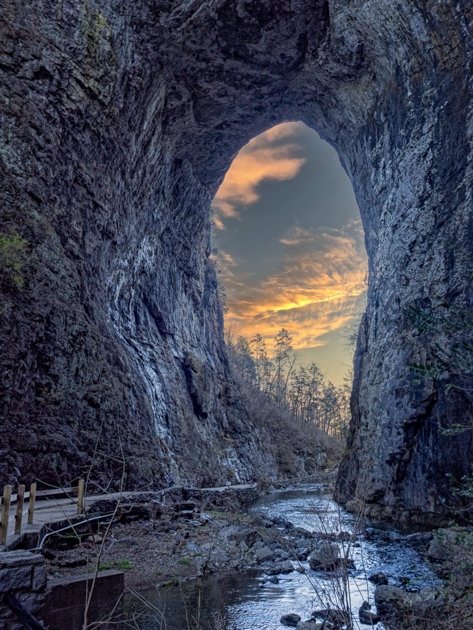 Natural Bridge in Lexington, VA silhouetted at sunset against a glowing sky
