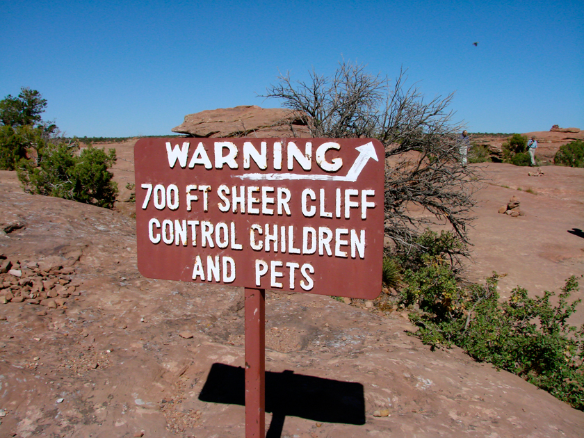 Sign warning of 700-foot sheer cliff at Canyon de Chelly National Monument, Arizona.