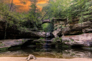 Natural rock bridge in Hocking Hills, Ohio, glowing in the warm light of sunset.