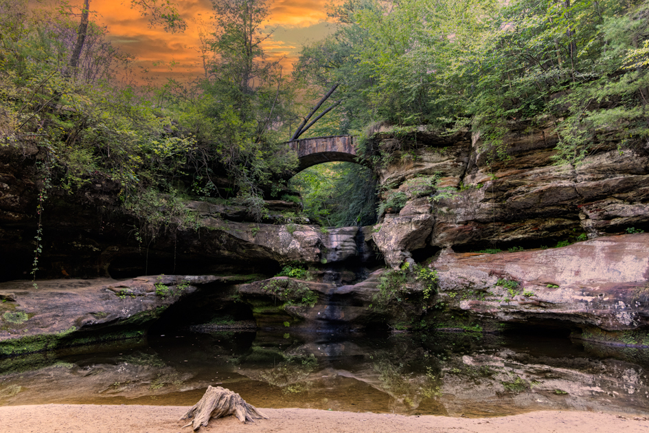 Natural rock bridge in Hocking Hills, Ohio, glowing in the warm light of sunset.