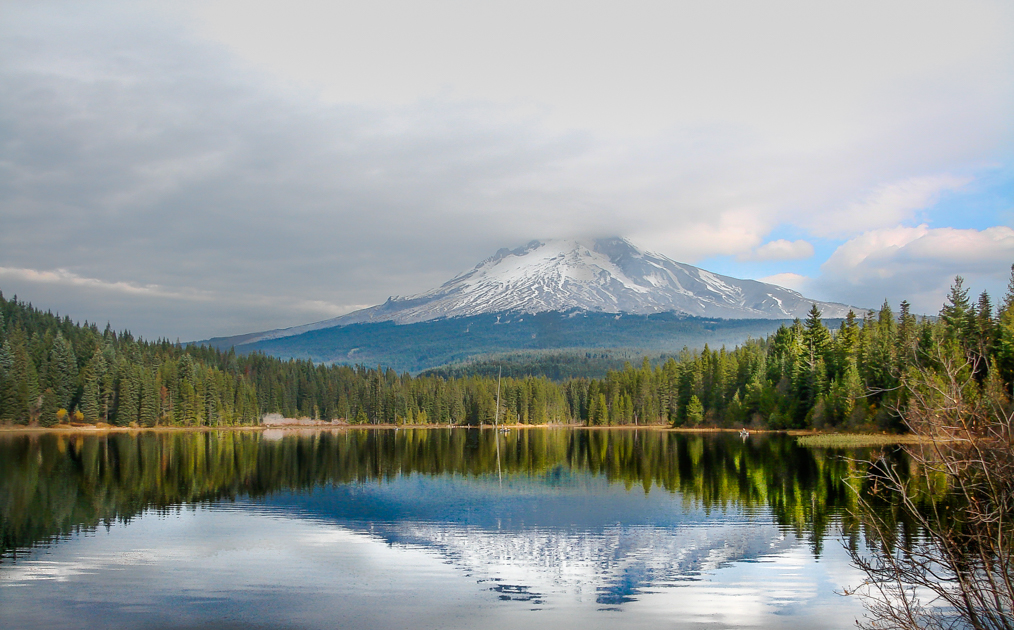 Trillium Lake with Mount Hood reflected under a moody, cloudy sky, creating a serene atmosphere.