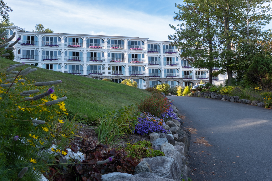 Road leading to Mirror Lake Inn in Lake Placid, lined with flowers and window boxes full of blooms.
