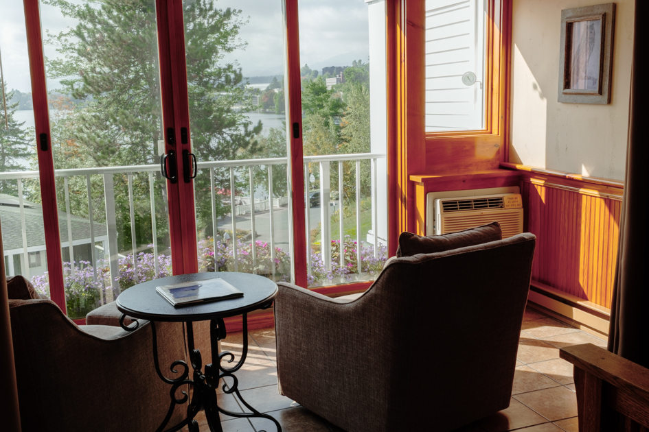 Sunroom in a Mirror Lake Inn hotel room with large windows overlooking Mirror Lake, Lake Placid.
