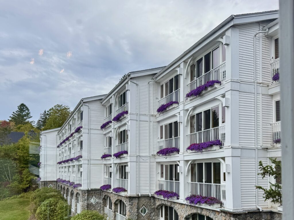 Mirror Lake Inn in Lake Placid with purple flowers in the window boxes.