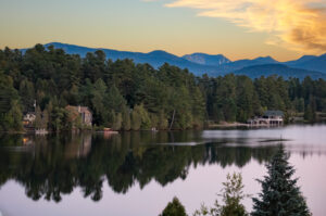 Mirror Lake in Lake Placid at sunrise with colorful reflections on the water Best travel cameras 2025 . Northeast road trip