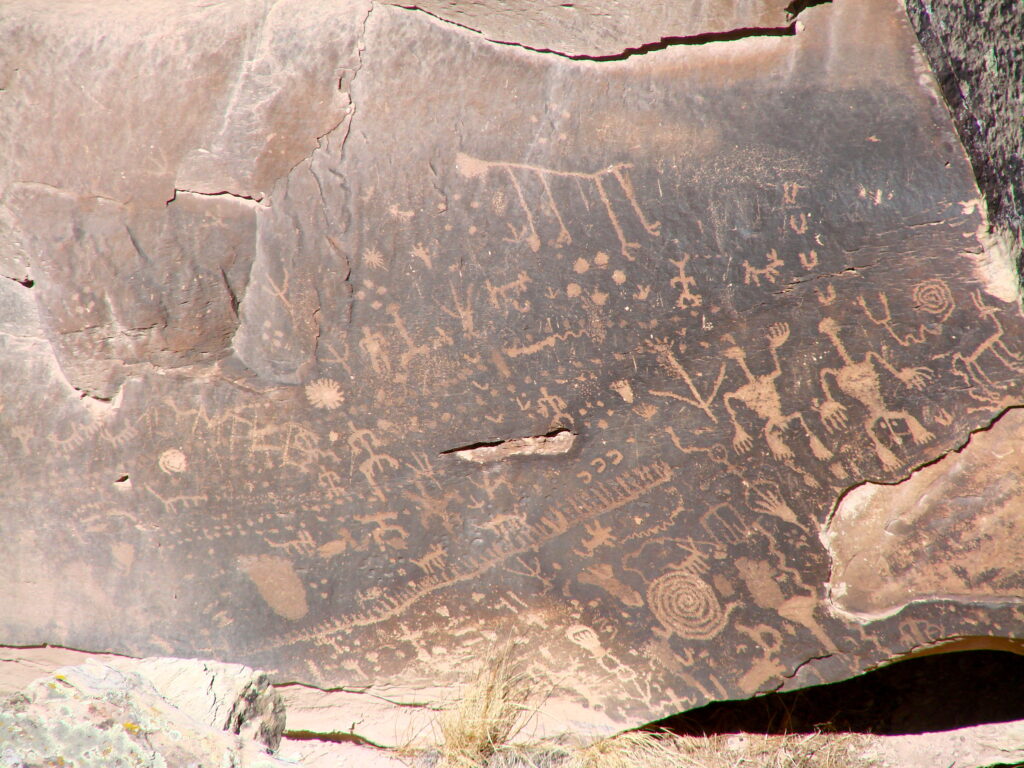 A close-up view of Newspaper Rock, showing intricate petroglyph carvings that tell the stories of hunting, rituals, and daily life.