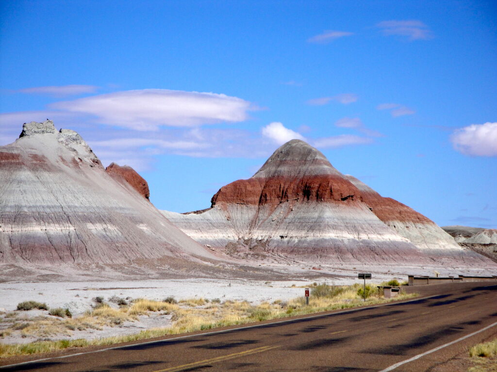 Layered, colorful hills of the Painted Desert with shades of red, pink, and beige