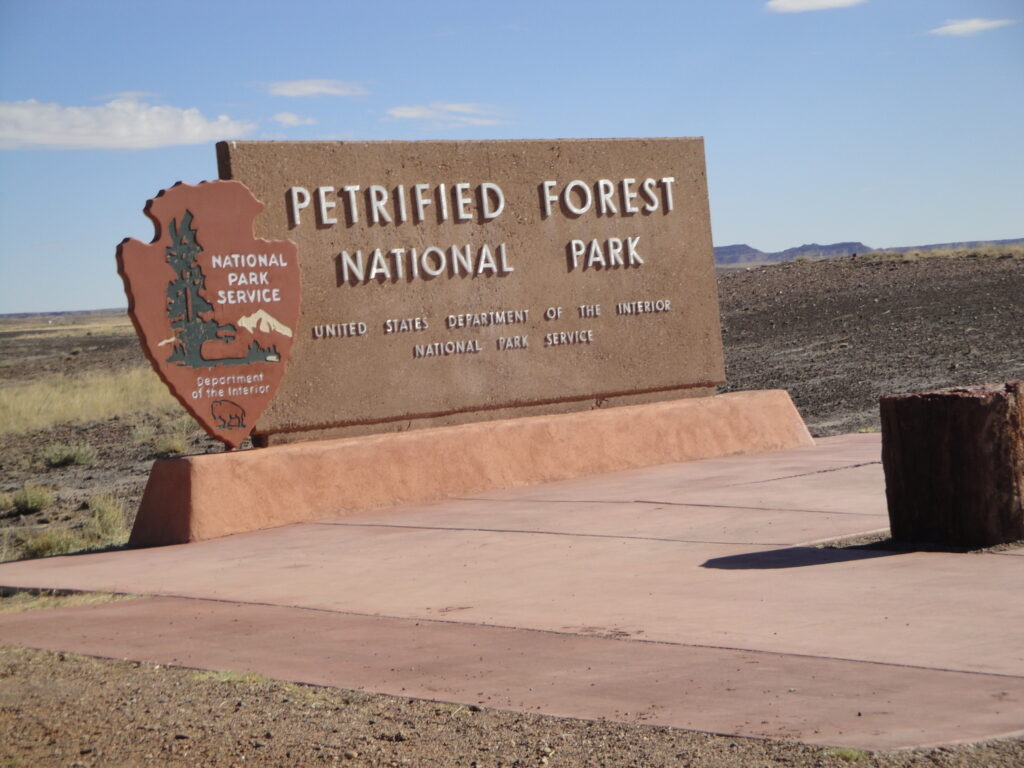 Entrance sign to Petrified Forest National Park in Arizona surrounded by desert landscape