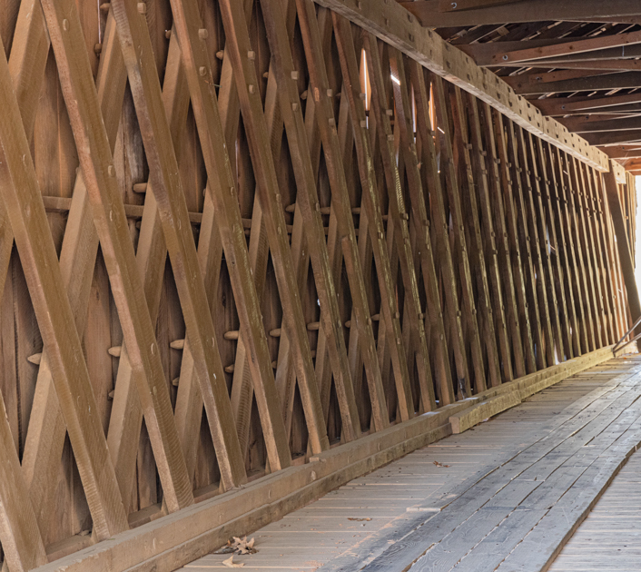 Interior view of Auchumpkee Creek Covered Bridge showing the wooden Town Lattice truss design in Thomaston, Georgia.