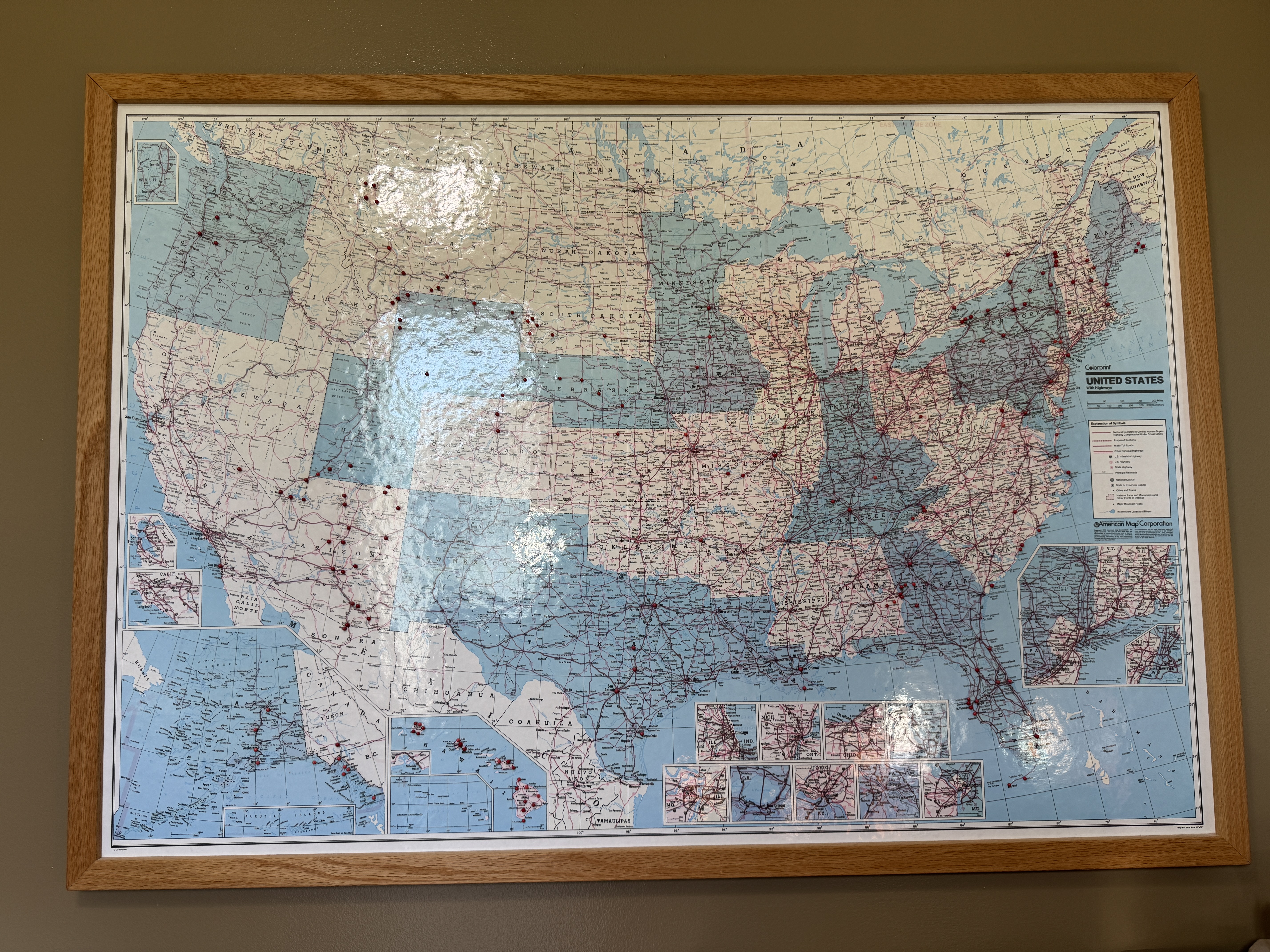 large map of United States hung on wall with pins for locations visited