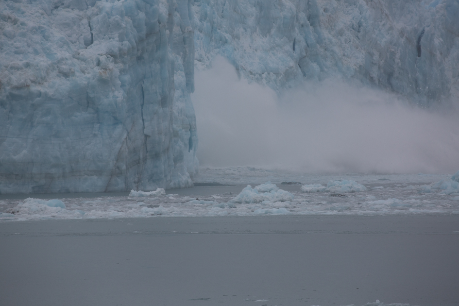 Large section of Hubbard Glacier breaking off and crashing into the sea during a calving event in Alaska.
