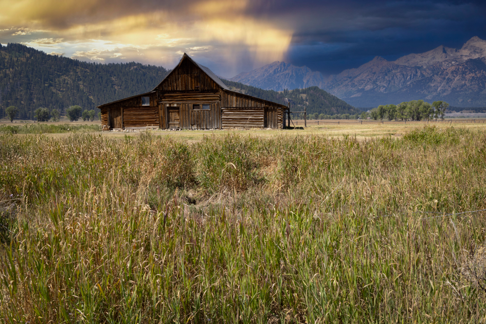 Sunrise over the historic T.A. Moulton Barn with the Teton Range glowing in morning light, Grand Teton National Park
