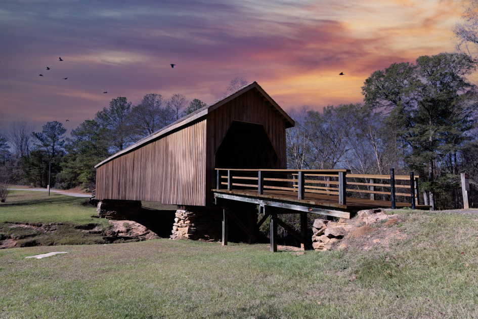 Auchumpkee Creek Covered Bridge surrounded by trees and quiet countryside in Thomaston, Georgia. at sunset