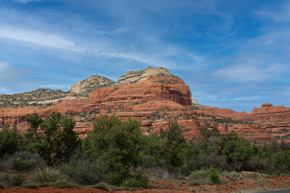Red rock formations glowing in late afternoon light along scenic Route 89A in Arizona

