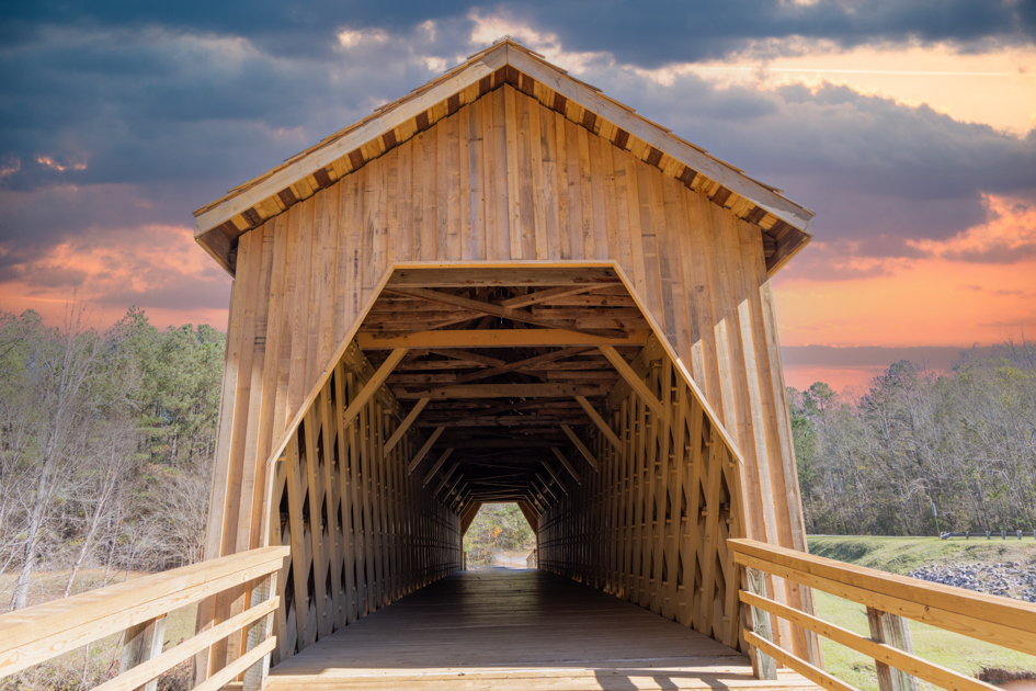 Auchumpkee Creek Covered Bridge surrounded by trees and quiet countryside in Thomaston, Georgia.