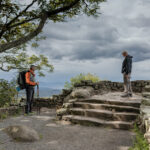 Hiker on the Appalachian Trail pausing to talk with another traveler along a wooded mountain path