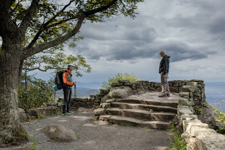 Hiker on the Appalachian Trail pausing to talk with another traveler along a wooded mountain path