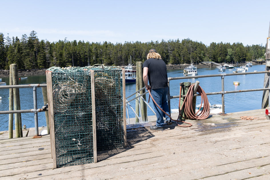 Lobstermen loading lobster traps into a boat
