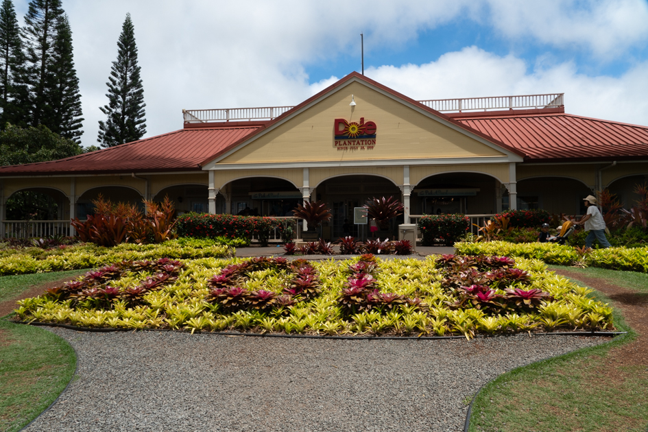Front entrance of Dole Plantation with yellow building and red roof on Oahu, Hawaii.  Oahu Travel guide