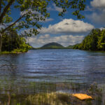 Early morning reflection of Eagle Lake surrounded by forest and Carriage Roads in Acadia National Park, Maine.