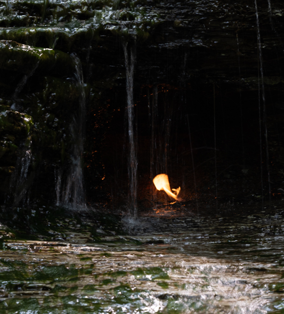 Natural gas flame flickering behind a small waterfall at Eternal Flame Falls in Orchard Park, New York