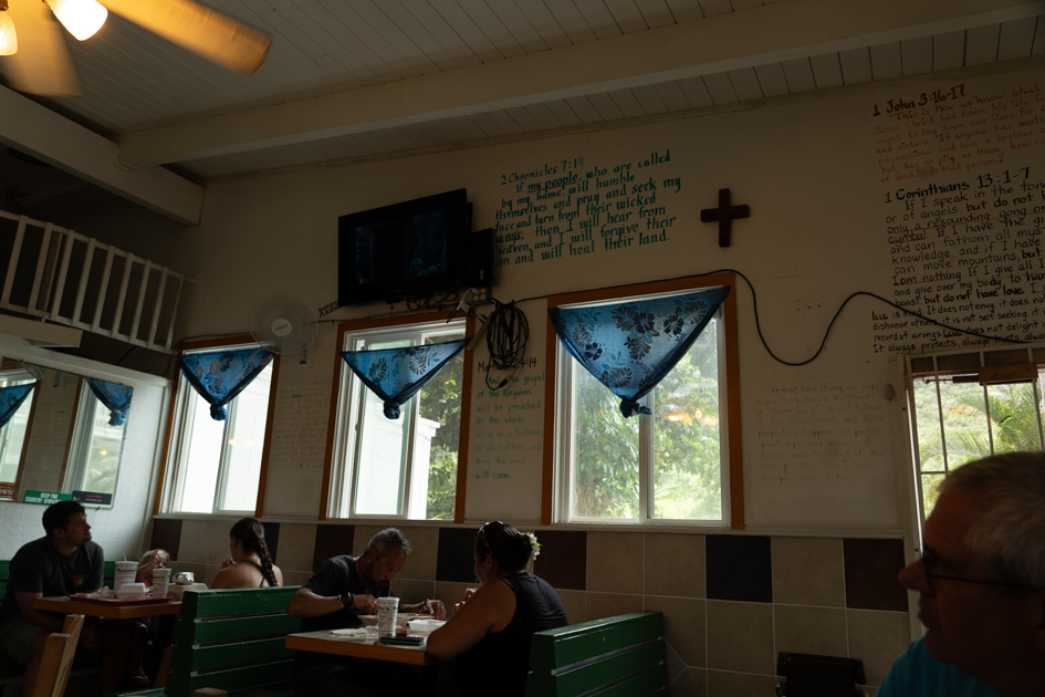Another view inside Keneke’s Grill showing the counter area and handwritten menu boards in Waimānalo, Oahu