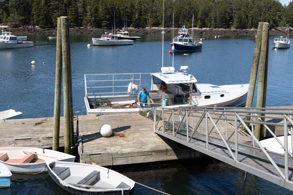 Lobstermen loading lobster traps into a boat
