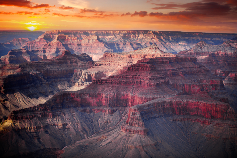 Grand Canyon glowing at sunrise with soft light illuminating red and orange canyon walls