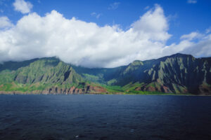 Panoramic view of the Nā Pali Cliffs rising above the Pacific Ocean on Kauai.
